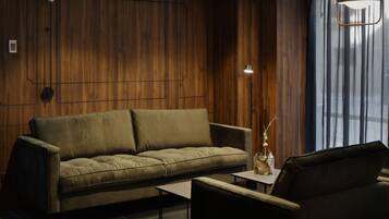 A modern living room with a sofa, a coffee table, and a lamp.