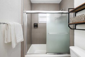 Bathtub, hair dryer, towels, shampoo
