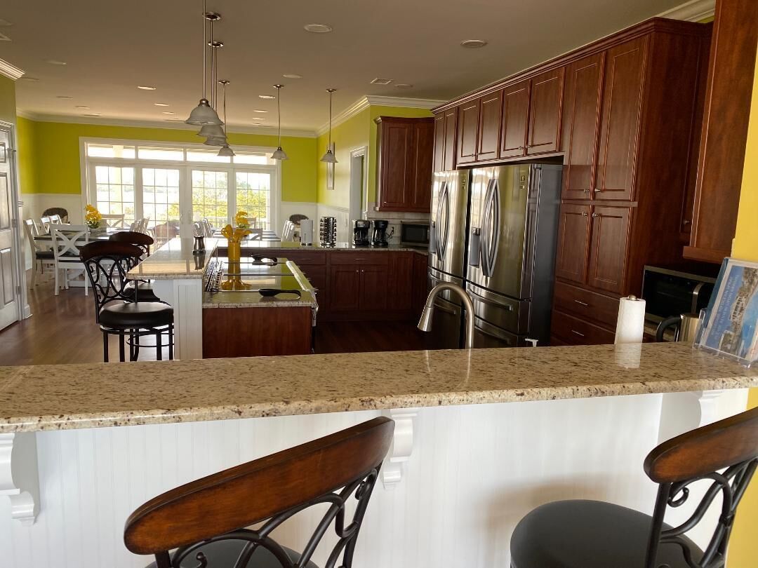 A modern kitchen with a central island, stainless steel appliances, and wooden cabinets.