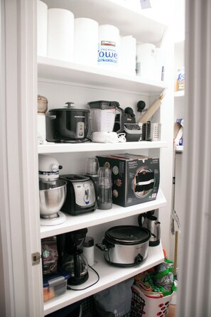 Een keuken met diverse apparaten, waaronder een blender, koffiezetapparaat en slowcooker.