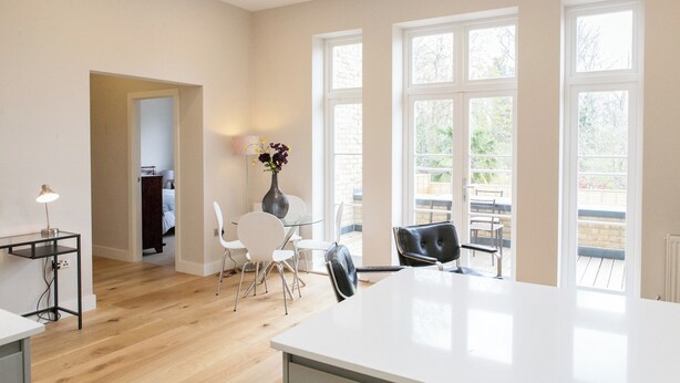 A spacious room with a large window, a dining table, chairs, and a lamp. - Beautiful 2 bed terrace flat close to Greenwich -  Pass the Keys (London)