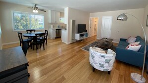 A spacious living room with a dining area, a kitchen, and a TV.