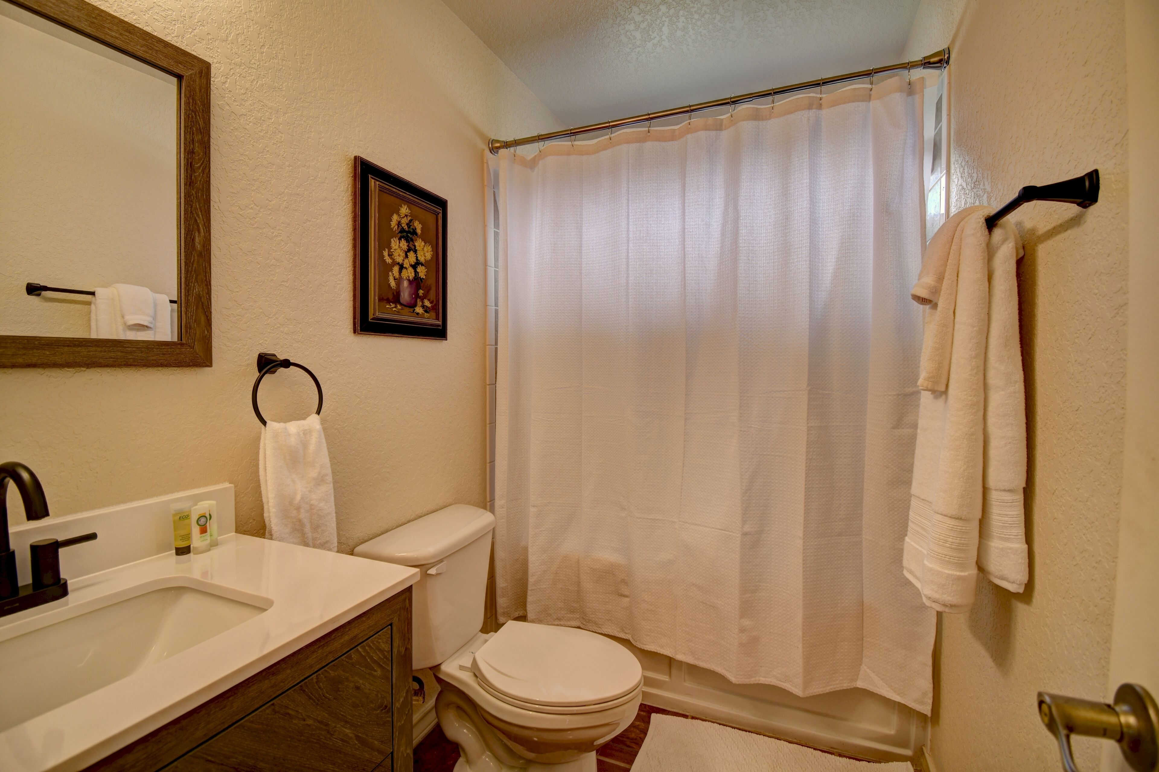 Une salle de bain avec des toilettes, un lavabo et un rideau de douche.
