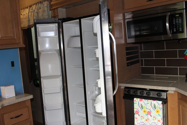 A kitchen with a refrigerator, microwave, and stove. - Luxury 5th Wheel Glamping In Style In Historic Mentone, Alabama (Mentone)