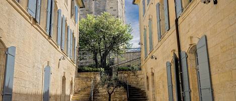 A cobblestone street leading to a historic building with a tower.