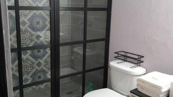 Chuveiro, toalhas de banho, sabonete, papel higiênico