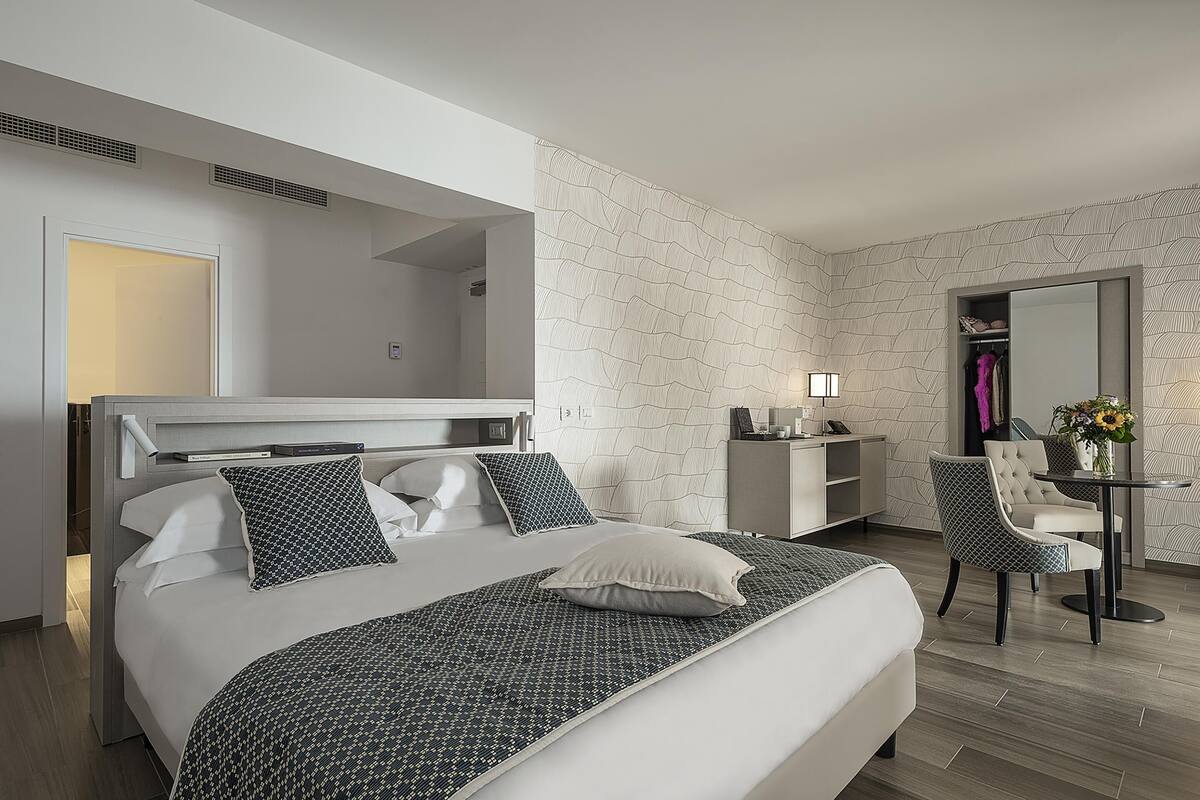 Een moderne hotelkamer met een groot bed, een bureau en een stoel.