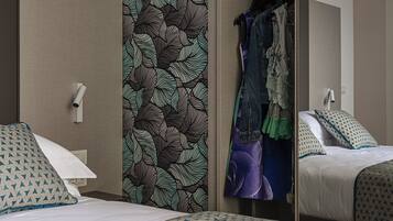 Une chambre d’hôtel avec un lit, une armoire et un miroir.