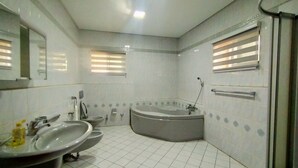 Une salle de bain moderne avec une baignoire, deux lavabos et des toilettes.