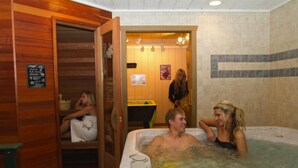 Eine Sauna mit Holzwänden und Fliesenboden, einer Sitzbank und einem Schild mit Anweisungen.
