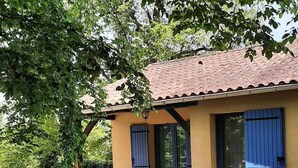 A house with a patio, a table, and chairs. - Village of 10 lodgings with heated outdoor swimming pool, restaurant on 1 hectare (Calviac en Périgord)