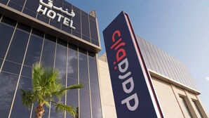 A hotel with a modern facade, a palm tree in front, and a prominent sign with the hotel's name. - Dara Hotel Qurtubah (Riyadh)