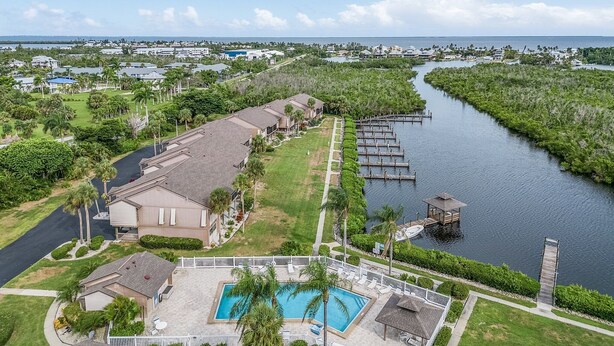A residential area with a swimming pool, dock, and waterfront view.