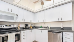 A modern kitchen with white cabinets, a built-in microwave, stove, and dishwasher. - Blue Crab Key Condo with Amazing Water Views! (Saint James City)
