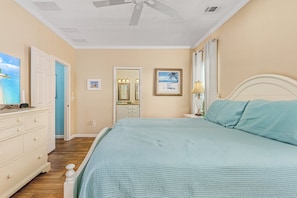 Une chambre à coucher avec un lit, une commode et un ventilateur de plafond.