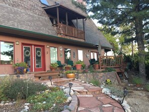 A two-story house with a red door, a balcony, and a stone pathway leading to the entrance. - Juniper Retreat (Farmington)
