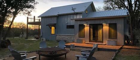 A modern house with a patio area featuring outdoor seating and a fire pit.