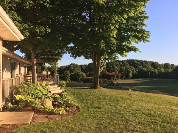 A house with a covered porch, a lawn, and a view of a golf course.
