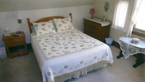 A bedroom with a bed, a nightstand, a dresser, a lamp, and a small table with a lamp. - Quiet Getaway Within Walking Distance of the Beach and Mall. (Cape May)