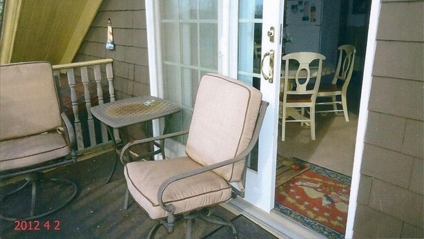 A porch with a rocking chair, a table, and a chair. - Quiet Getaway Within Walking Distance of the Beach and Mall. (Cape May)