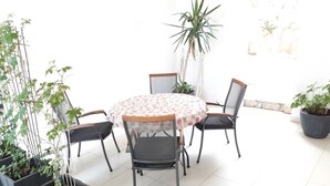 A round table with a floral tablecloth surrounded by four chairs, a potted plant, and a tall plant in the background. - Apartment in Brela with Seaview, Balcony, Air condition, WIFI (4962-1) (Brela)