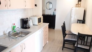 A compact kitchen with a sink, microwave, coffee maker, and a dining area with a table and chairs. - Apartment in Brela with Seaview, Balcony, Air condition, WIFI (4962-1) (Brela)