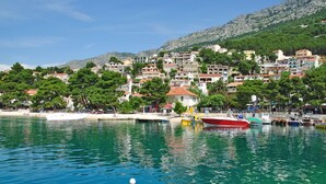 A coastal town with buildings along the waterfront, a marina with boats, and a clear blue sea. - Apartment in Brela with Seaview, Balcony, Air condition, WIFI (4962-1) (Brela)