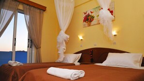 Quarto de hotel com duas camas, uma janela grande com cortinas, um quadro na parede e uma mesa de cabeceira com abajur.