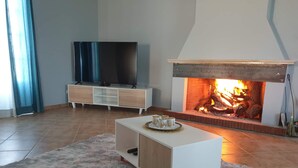 Ein Wohnzimmer mit Kamin, Fernseher und einem weißen Unterhaltungsschrank.