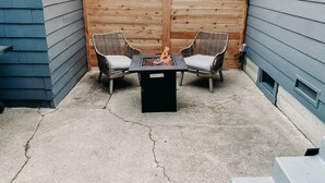 A patio area with two wicker chairs, a small table, and a fire feature. - Modern House, Walk To Historic Downtown! (Grants Pass)
