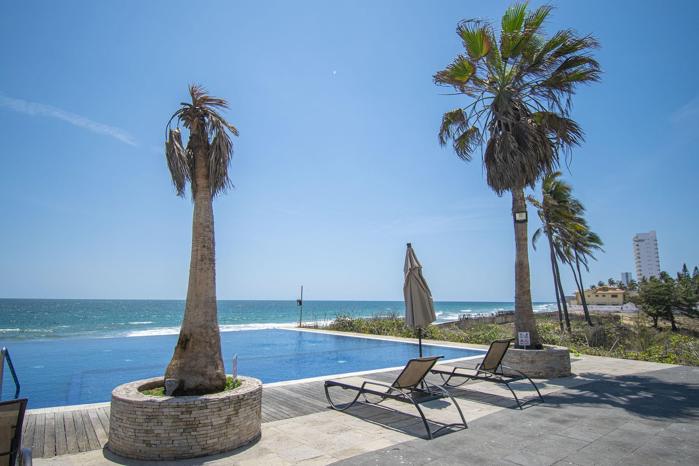 Et evighetsbasseng, et oppvarmet basseng og solsenger