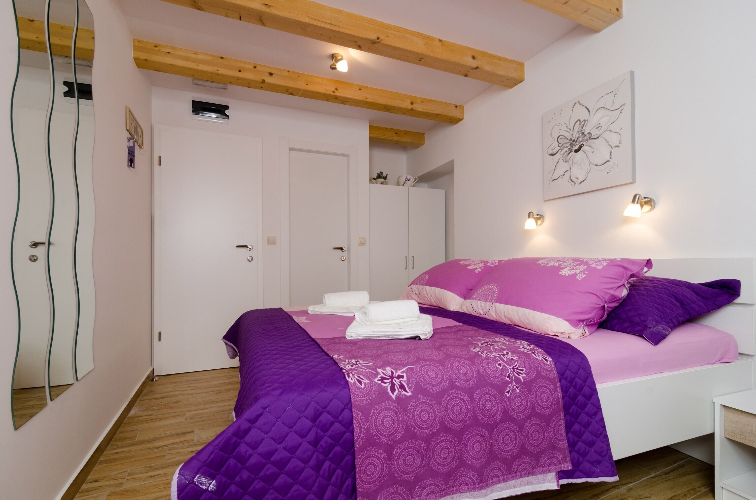 Un dormitorio con una cama, un armario blanco y una lámpara de pared.