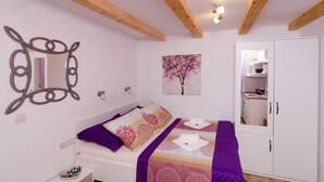Ein Schlafzimmer mit Bett, Kleiderschrank, Spiegel und einem Gemälde.