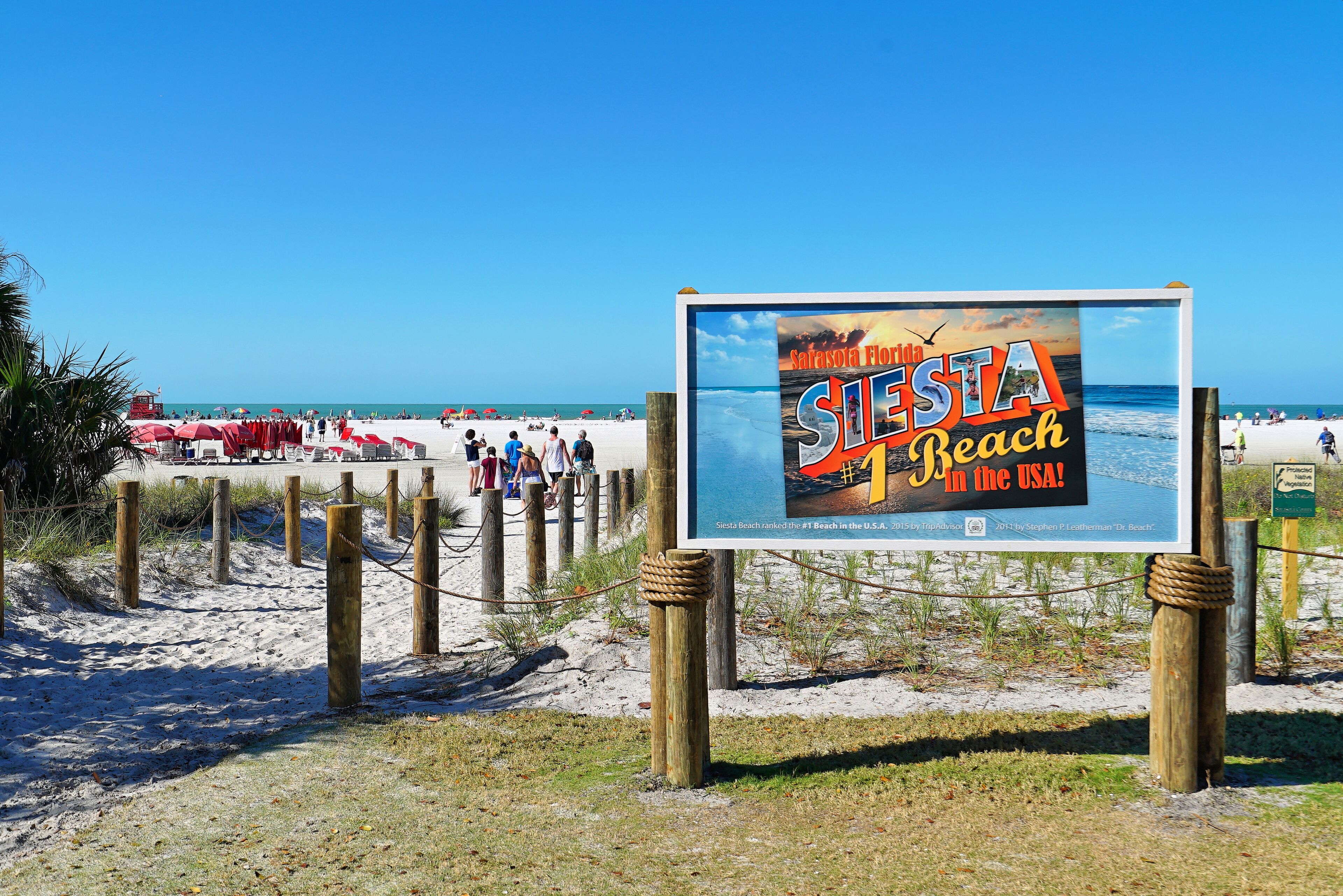 Um sinal de praia com o texto 'Siesta Beach nos EUA' e a informação de que é a praia número 1 dos EUA.