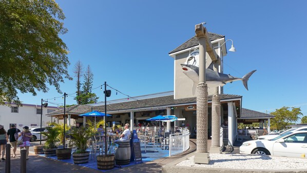 Un bâtiment doté d’une tour horlogée, d’une terrasse et d’une grande sculpture de requin.