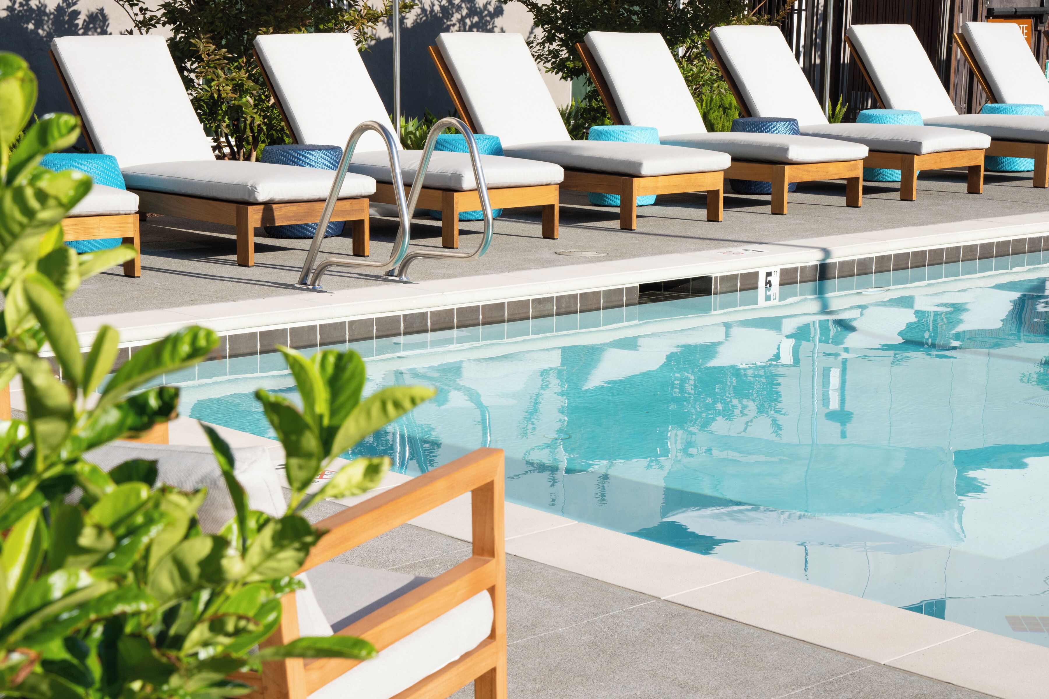 Zona junto a la piscina con sillones de descanso y una piscina.