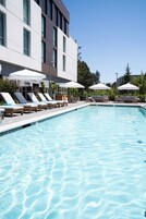 Una piscina al aire libre, sillones reclinables de piscina