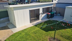 Et moderne hus med stor skydedør, tøjsnor og en indhegnet have.