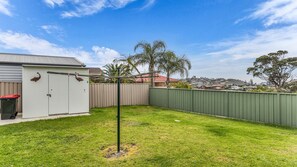 A residential backyard with a fenced area, a shed, and a small tree. - Fishos Hangout 1 - Unit 1 Sinclair St 21 (BERMAGUI)