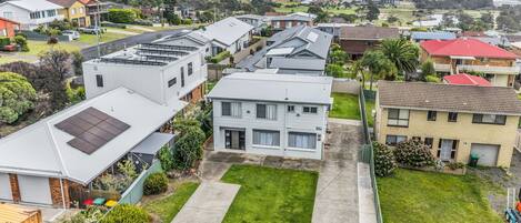 A residential area with houses, a grassy front yard, and a clear view of the surrounding landscape.