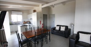 A modern apartment with a dining area, kitchen, and living space. - Fishos Hangout 1 - Unit 1 Sinclair St 21 (BERMAGUI)