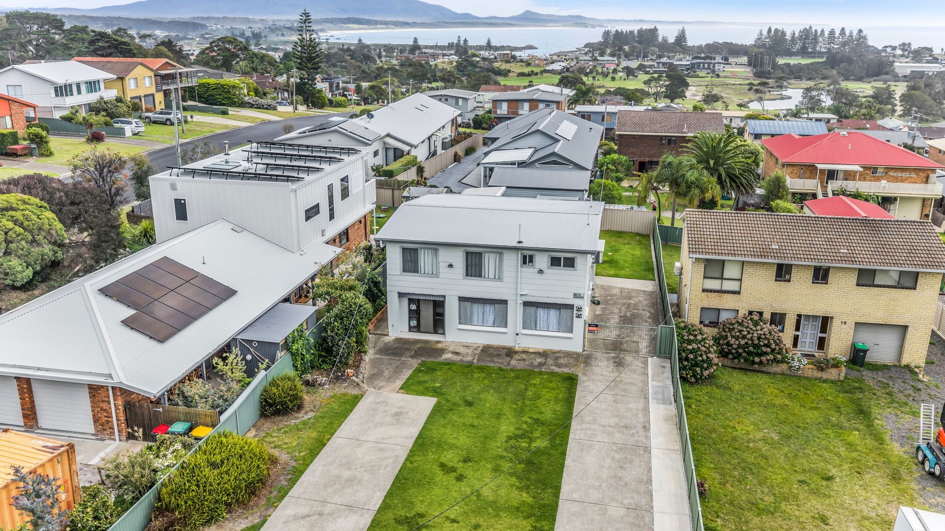 Un quartier résidentiel avec des maisons, une pelouse bien entretenue devant chaque maison et une vue dégagée sur le paysage environnant.