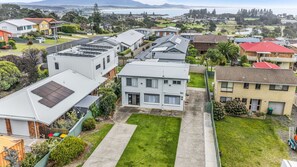 A residential area with houses, a grassy front yard, and a clear view of the surrounding landscape. - Fishos Hangout 2 - Unit 2 Sinclair St 21 (BERMAGUI)