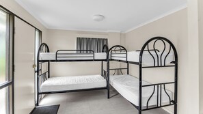 A bunk bed room with a window, a door, and a ceiling light.