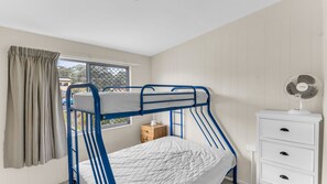 A bunk bed room with a window, a small wooden nightstand, and a white dresser with drawers. - Fishos Hangout 2 - Unit 2 Sinclair St 21 (BERMAGUI)