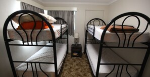 A room with bunk beds, a small bedside table with a lamp, and a door in the background. - Fishos Hangout 2 - Unit 2 Sinclair St 21 (BERMAGUI)