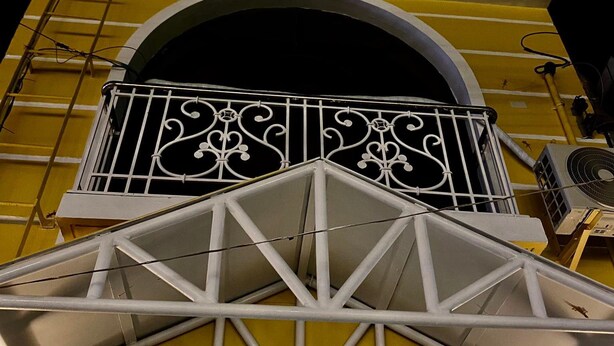 Un bâtiment jaune doté d’un balcon et d’une enseigne indiquant « 110, rue Salcedo ».