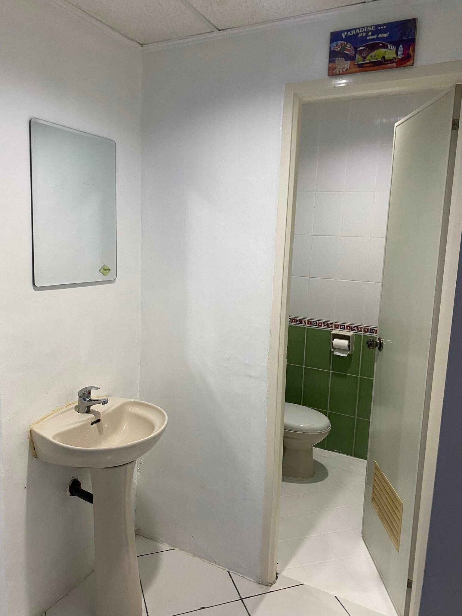 A small bathroom with a sink, mirror, and toilet.