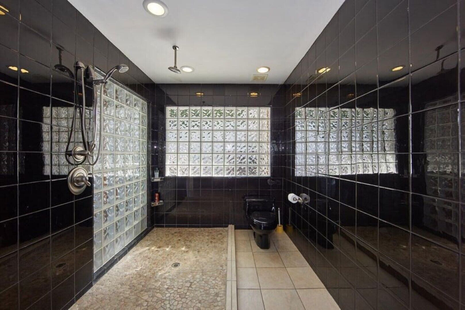 Ein modernes Badezimmer mit Duschkabine aus Glas, Toilette und Waschbecken.