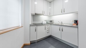 Eine moderne Küche mit weißen Schränken, einer Granit-Arbeitsplatte und einer Mikrowelle.